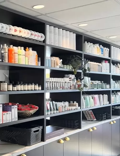 Modern hair salon retail wall displaying organized hair products and custom cabinetry.
