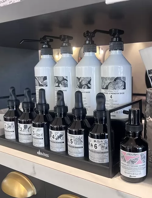 Davines hair treatment dropper bottles and pump dispensers neatly displayed on a shelf.
